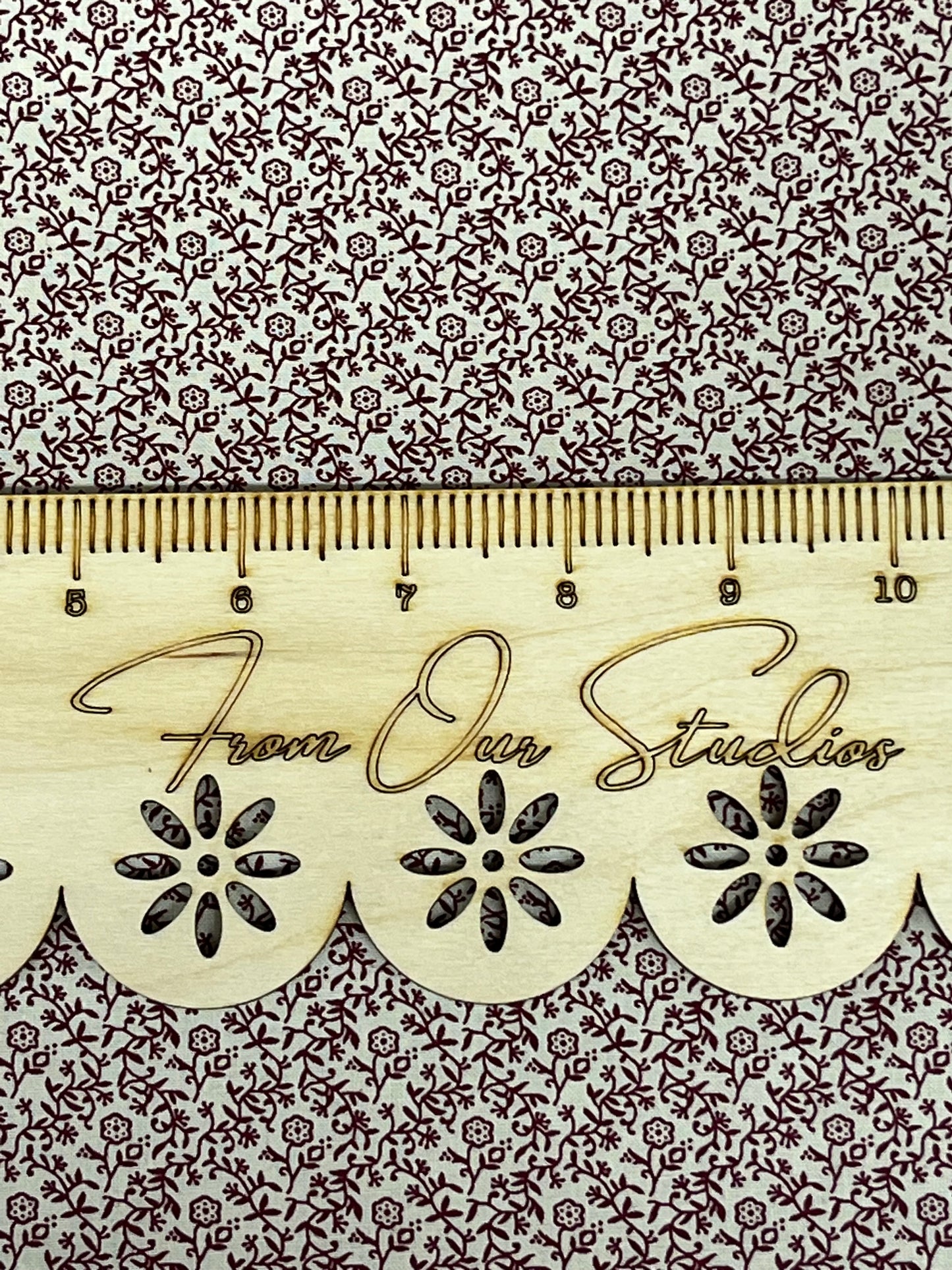 Vintage-inspired mauve floral vine fabric by Marshall Dry Goods, reproduction 1800s style, shown with wooden ruler for scale.