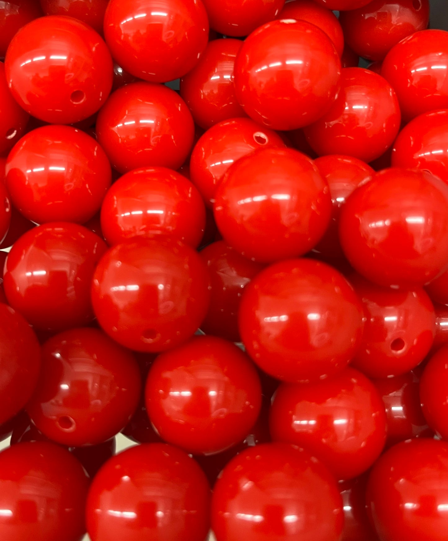 Close-up of glossy 20mm bright red bubblegum beads, perfect for jewelry making or junk journal crafts