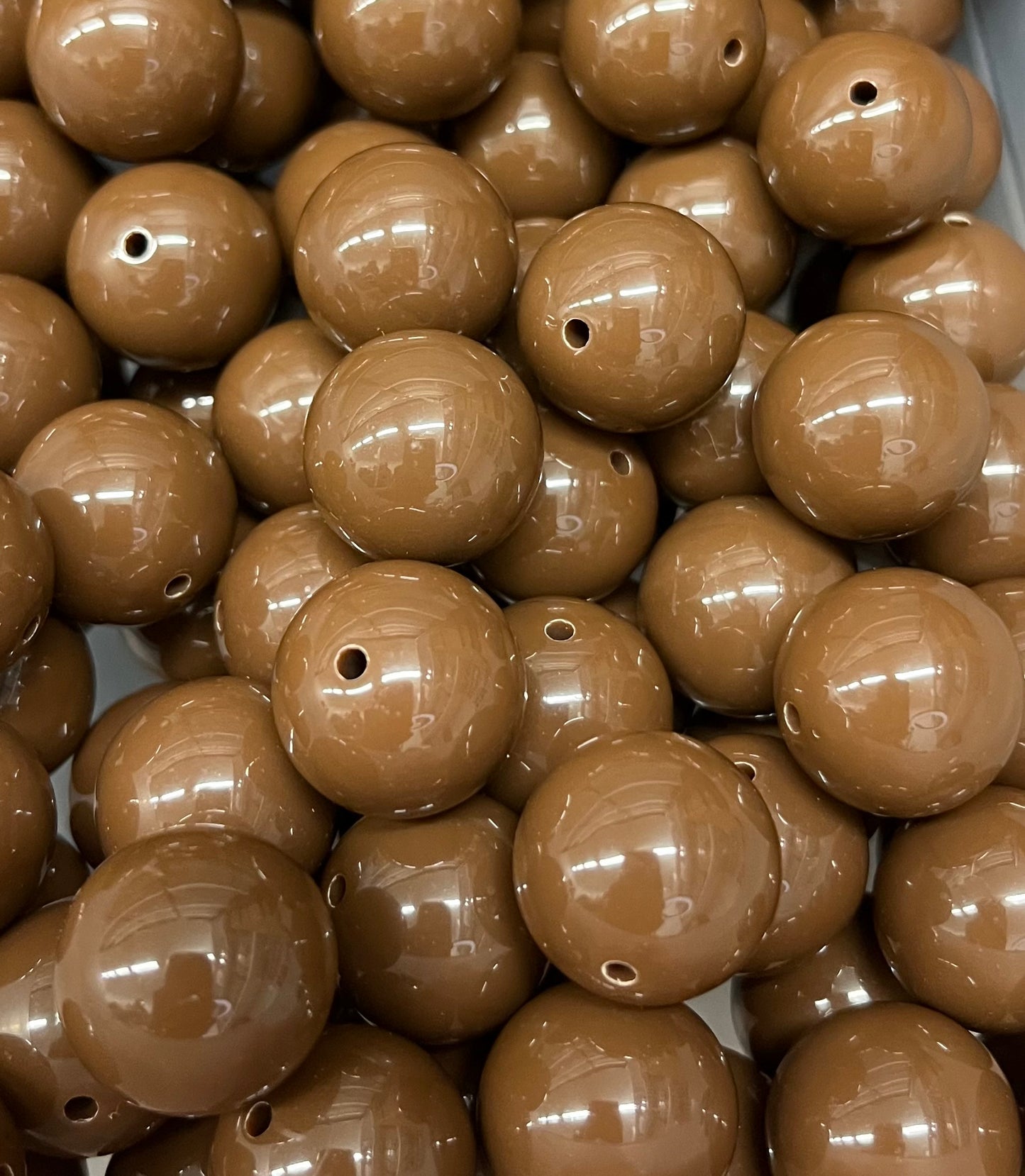 Close-up of glossy 20mm chocolate brown acrylic bubblegum beads for crafting and jewelry making
