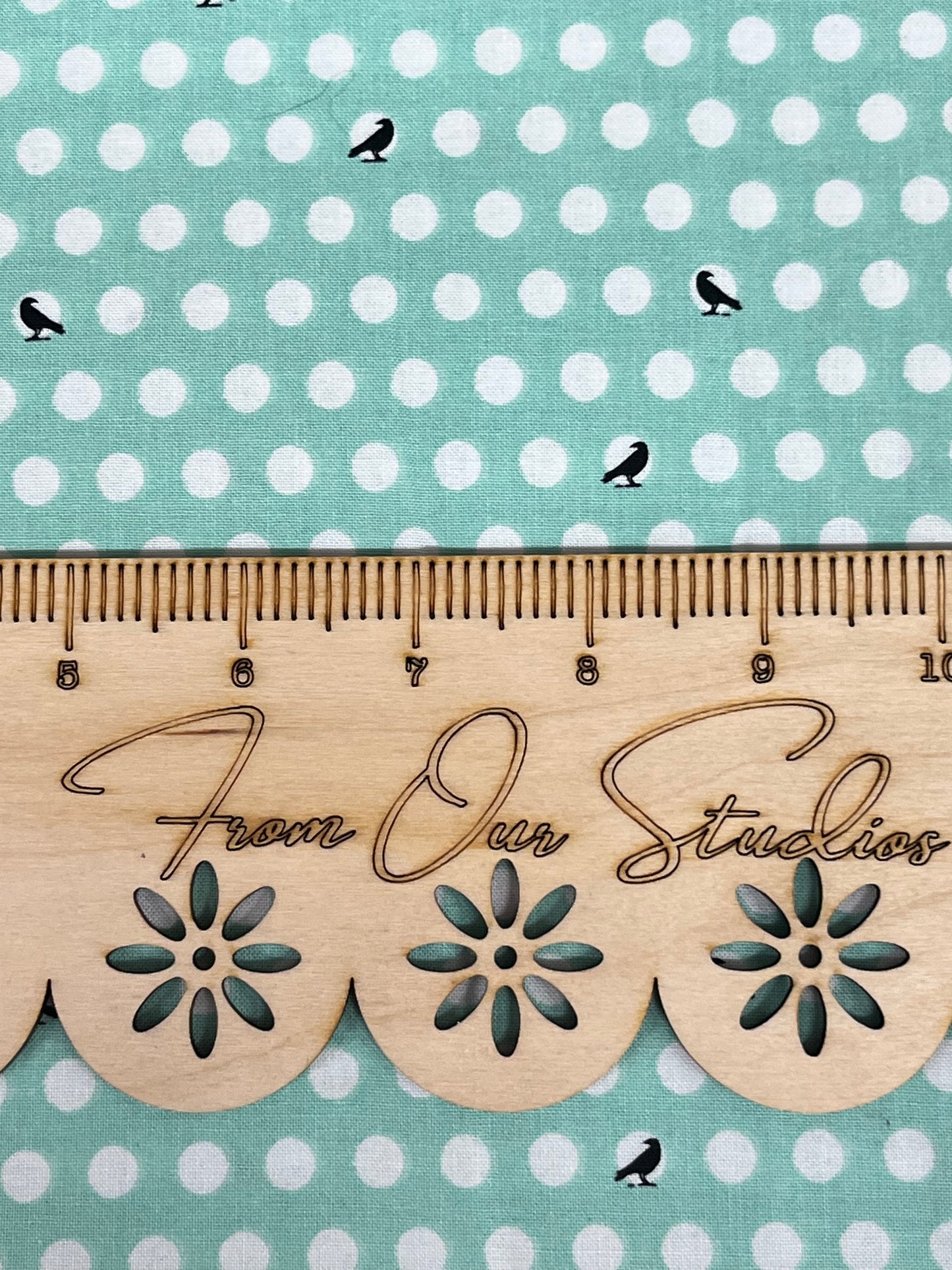 Close-up view of Riley Blake fat quarter showing playful black crow print on mint green cotton fabric.