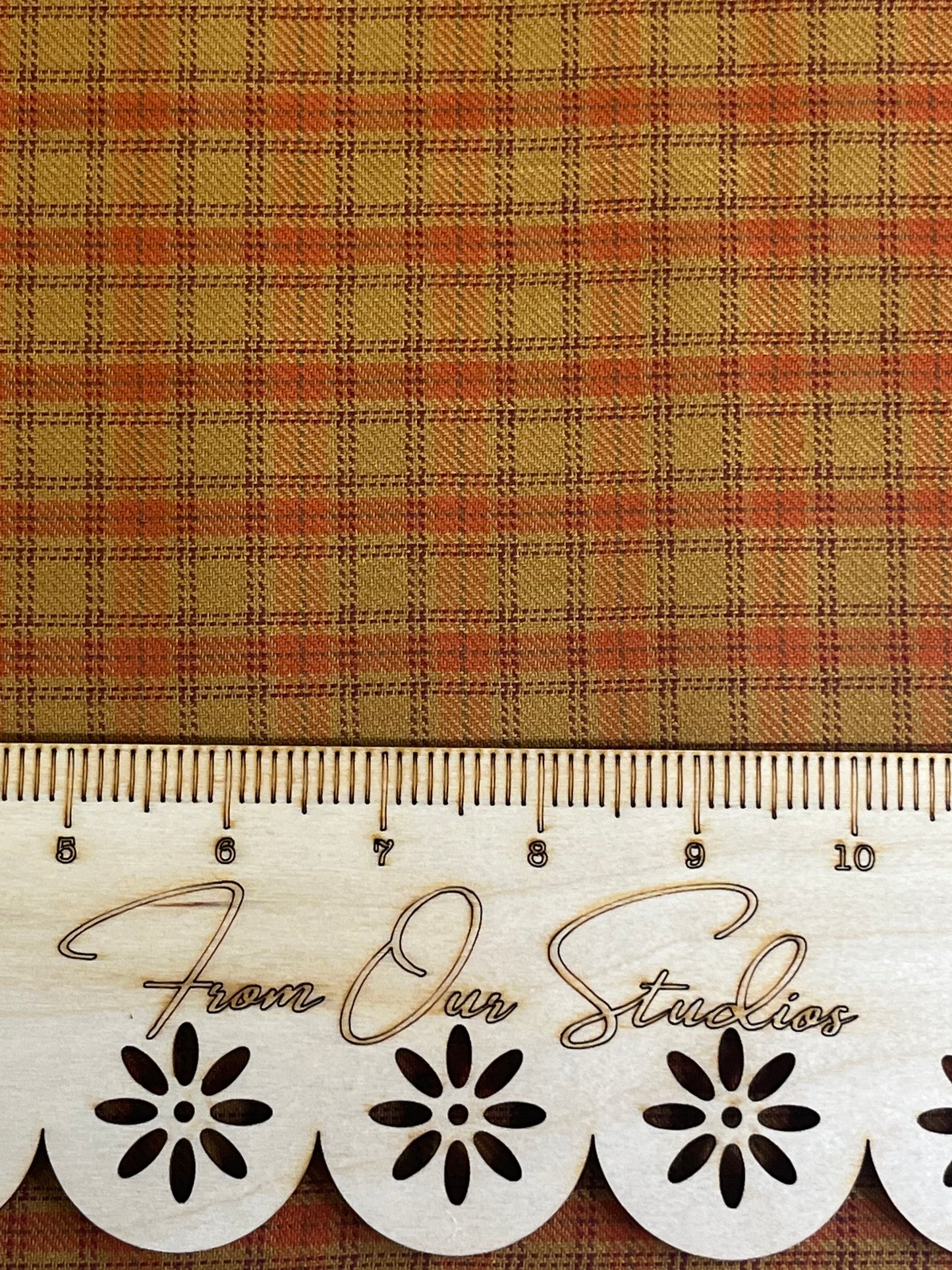 Detailed view of rustic plaid fabric in warm rust orange and mustard tones, medium-scale cotton print for sewing, quilting, and junk journal crafts