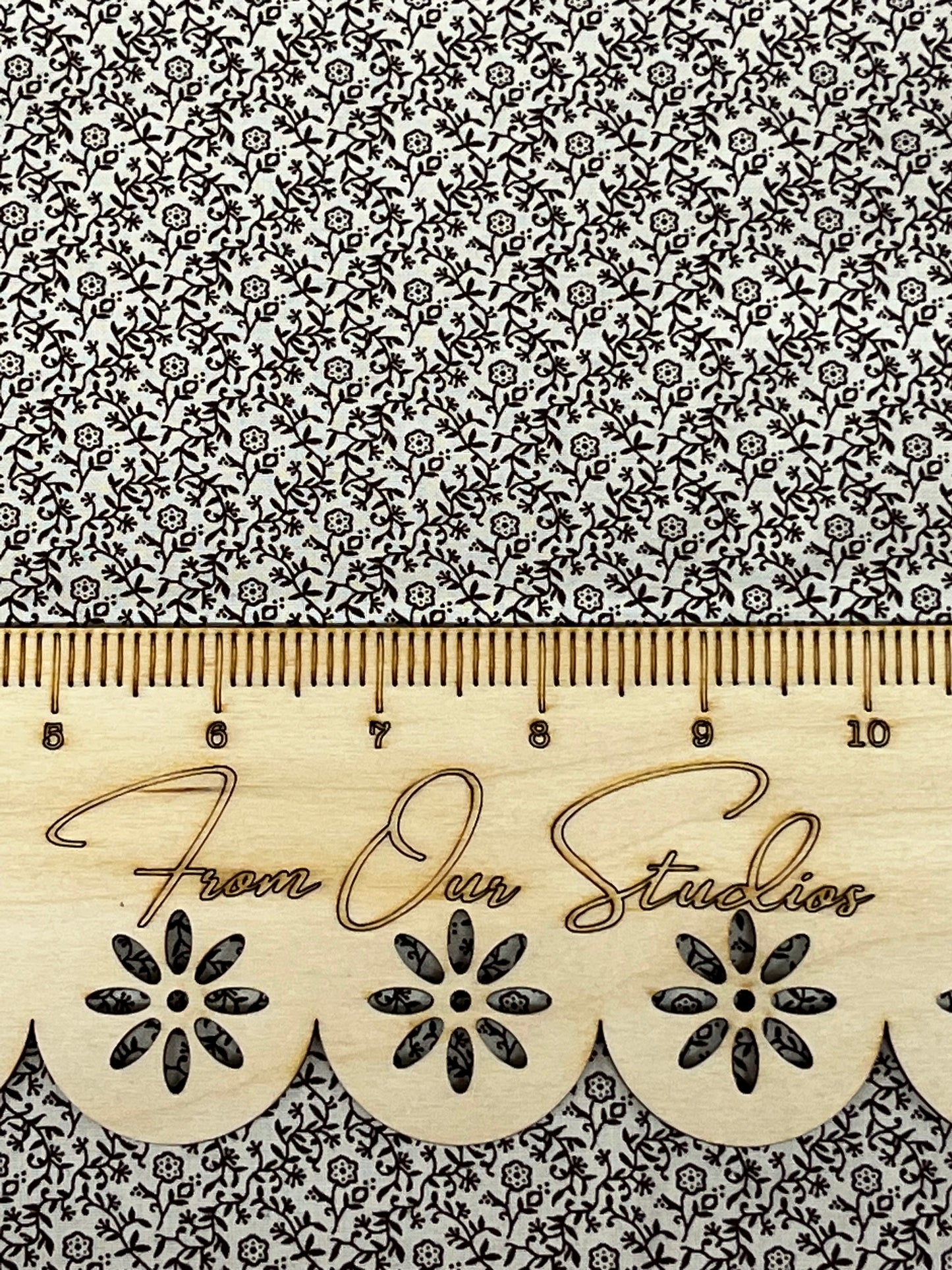 Cream fabric with chocolate brown floral vine print by Marshall Dry Goods, crisp quilting cotton shown with ruler for scale. Sold as fat quarter only.