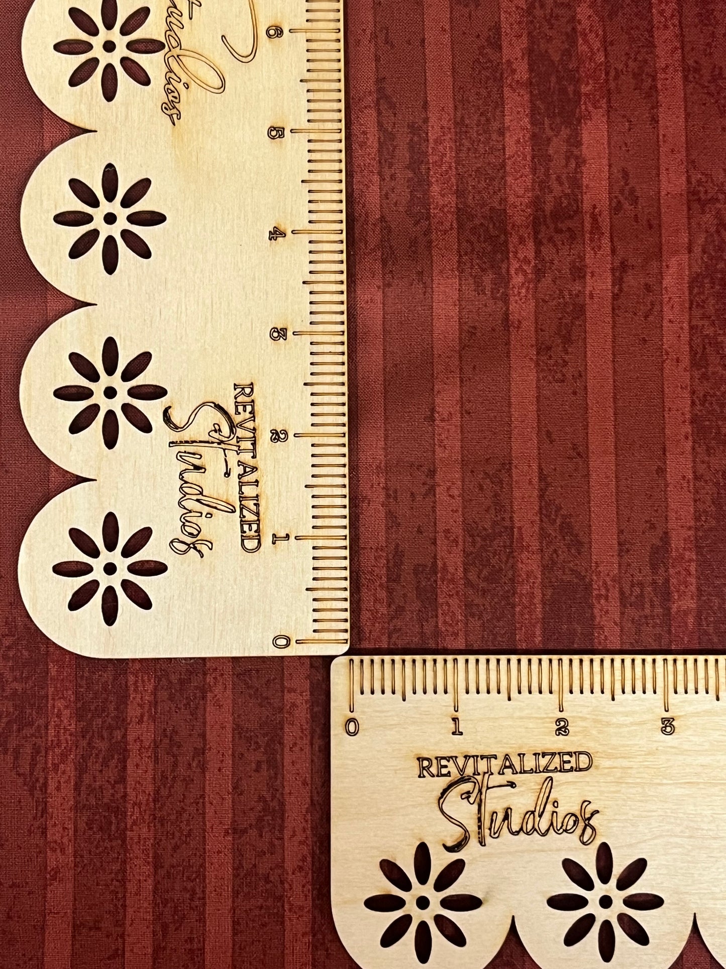 A close-up of a red striped fabric from the Kringle Collection by Teresa Kogut, showing the texture and brand embossment.