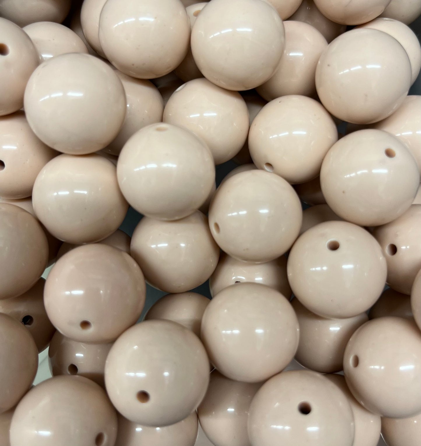 Close-up of glossy tan 20mm acrylic bubblegum beads for jewelry making and crafts
