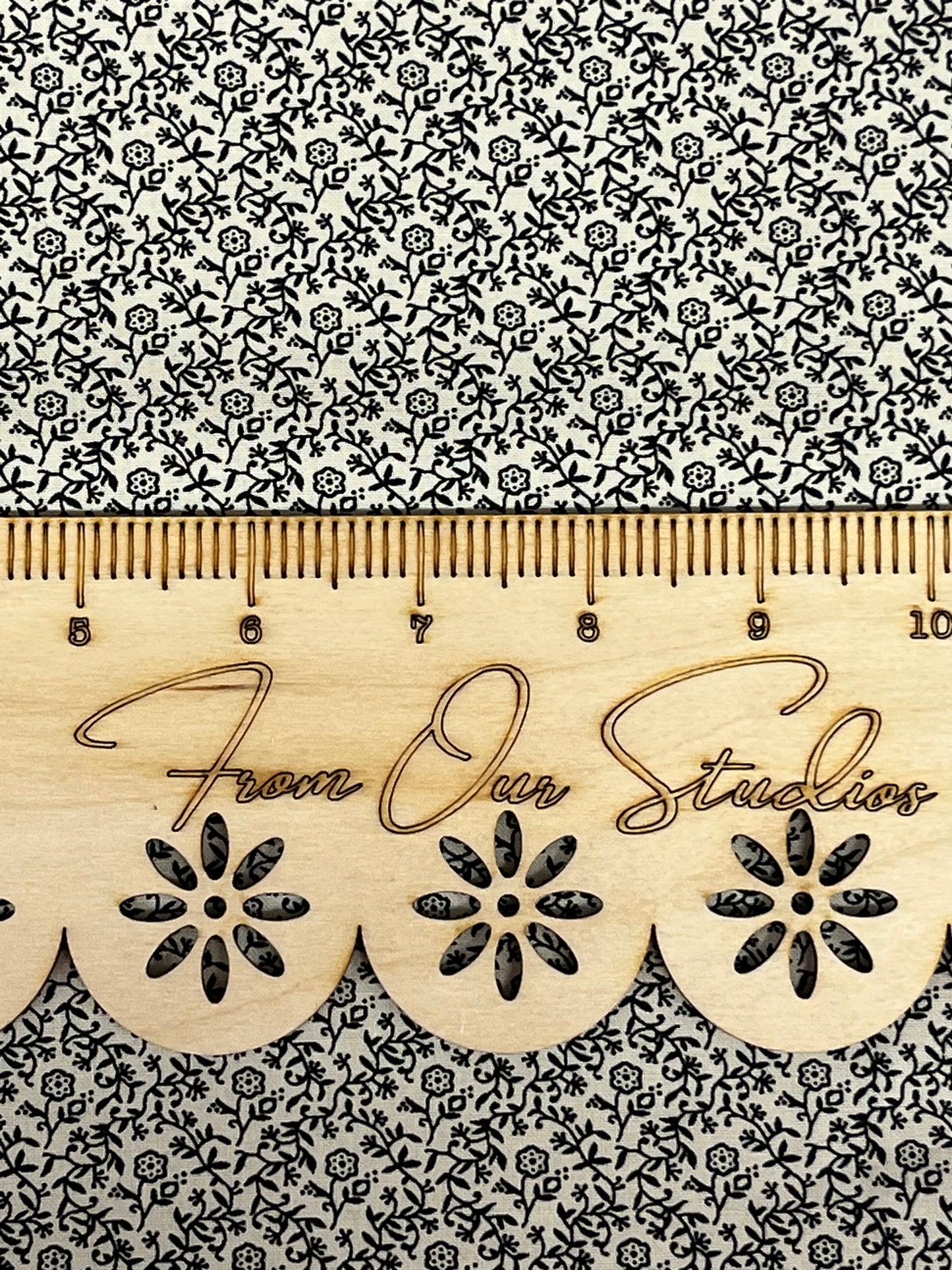 Close-up of Marshall Dry Goods 1800’s reproduction black floral cotton fabric, sold as a fat quarter. Ruler shown for scale only.