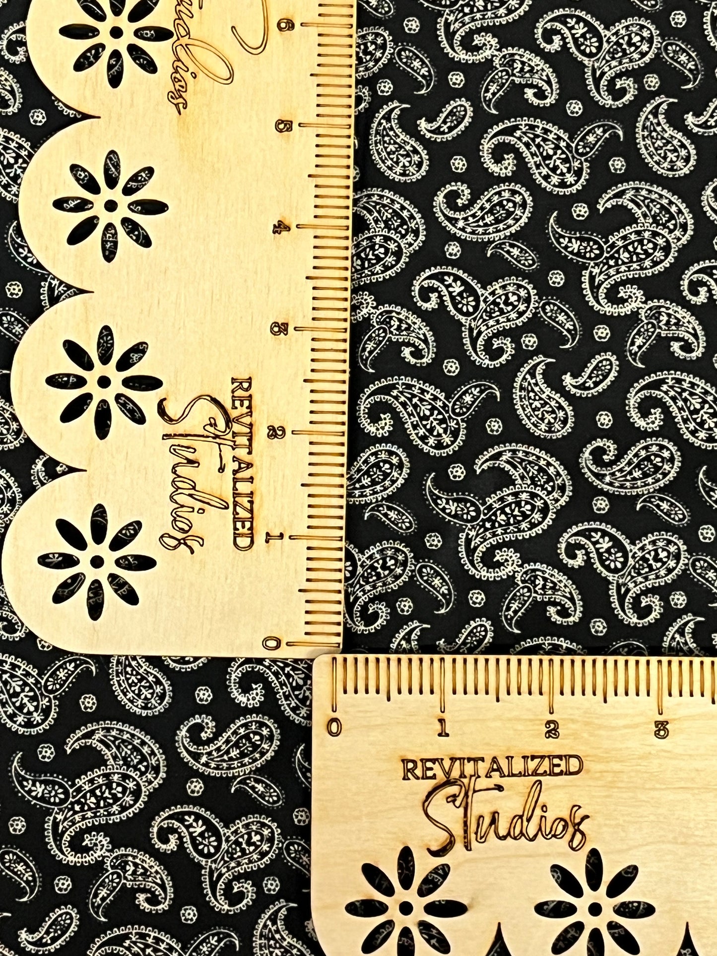 Marshall Dry Goods 1800s reproduction cotton fabric in black with cream paisley, shown with ruler for scale.