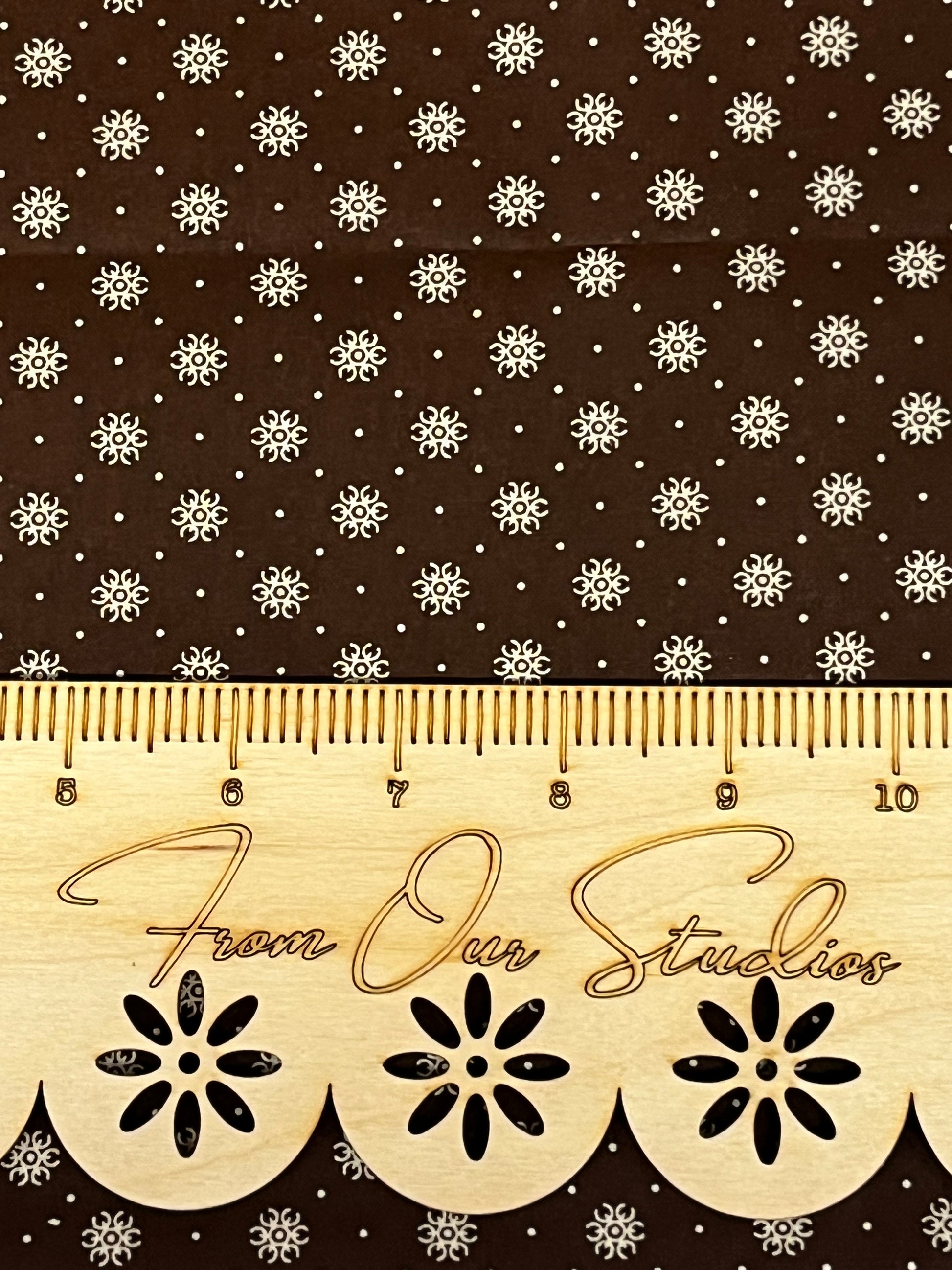 Close-up of brown reproduction cotton fabric with small cream star motifs, quilting weight fabric in fat quarter size.