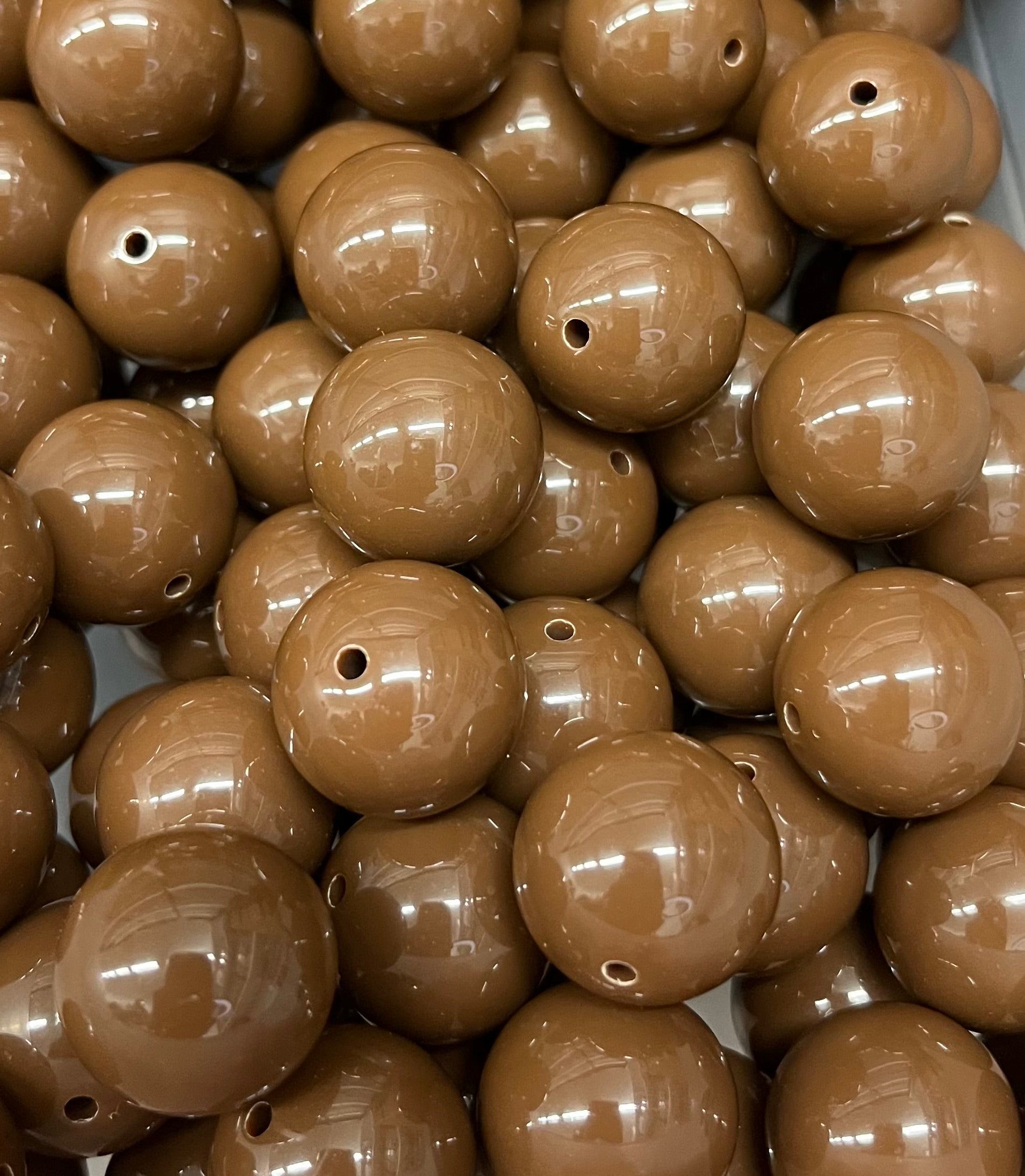Close-up of glossy 20mm chocolate brown acrylic bubblegum beads for crafting and jewelry making