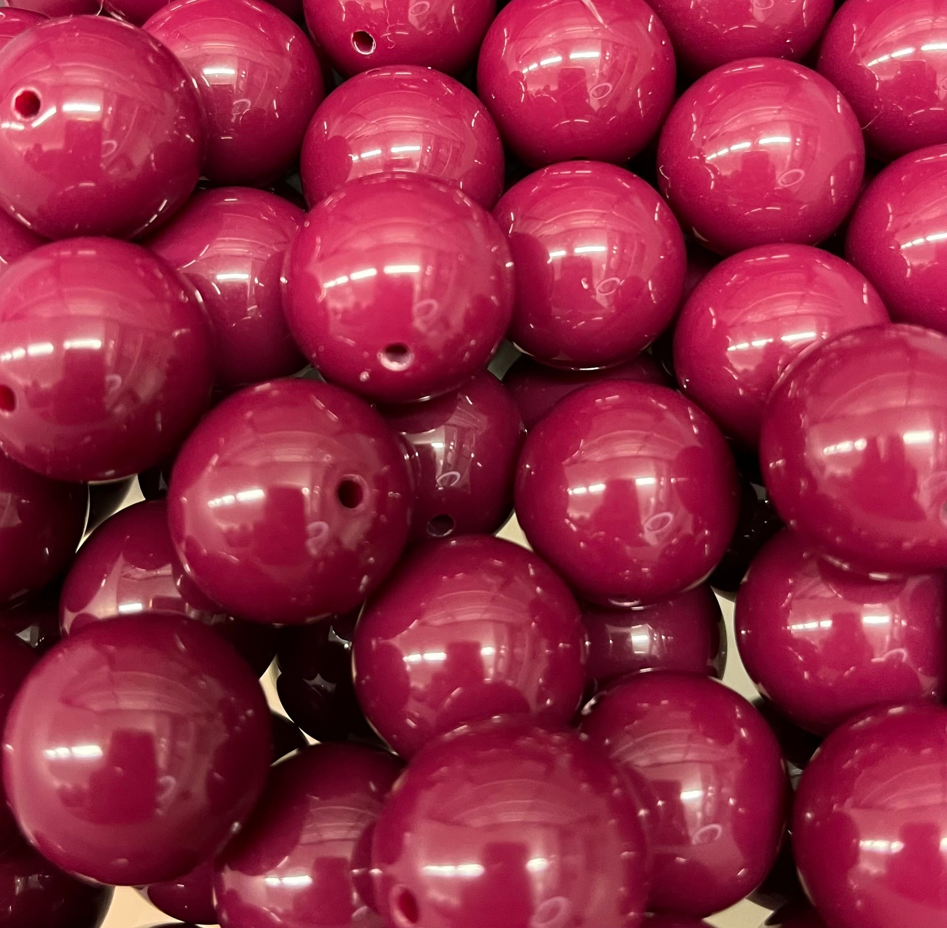Close-up of glossy 20mm cranberry bubblegum beads for jewelry and crafts