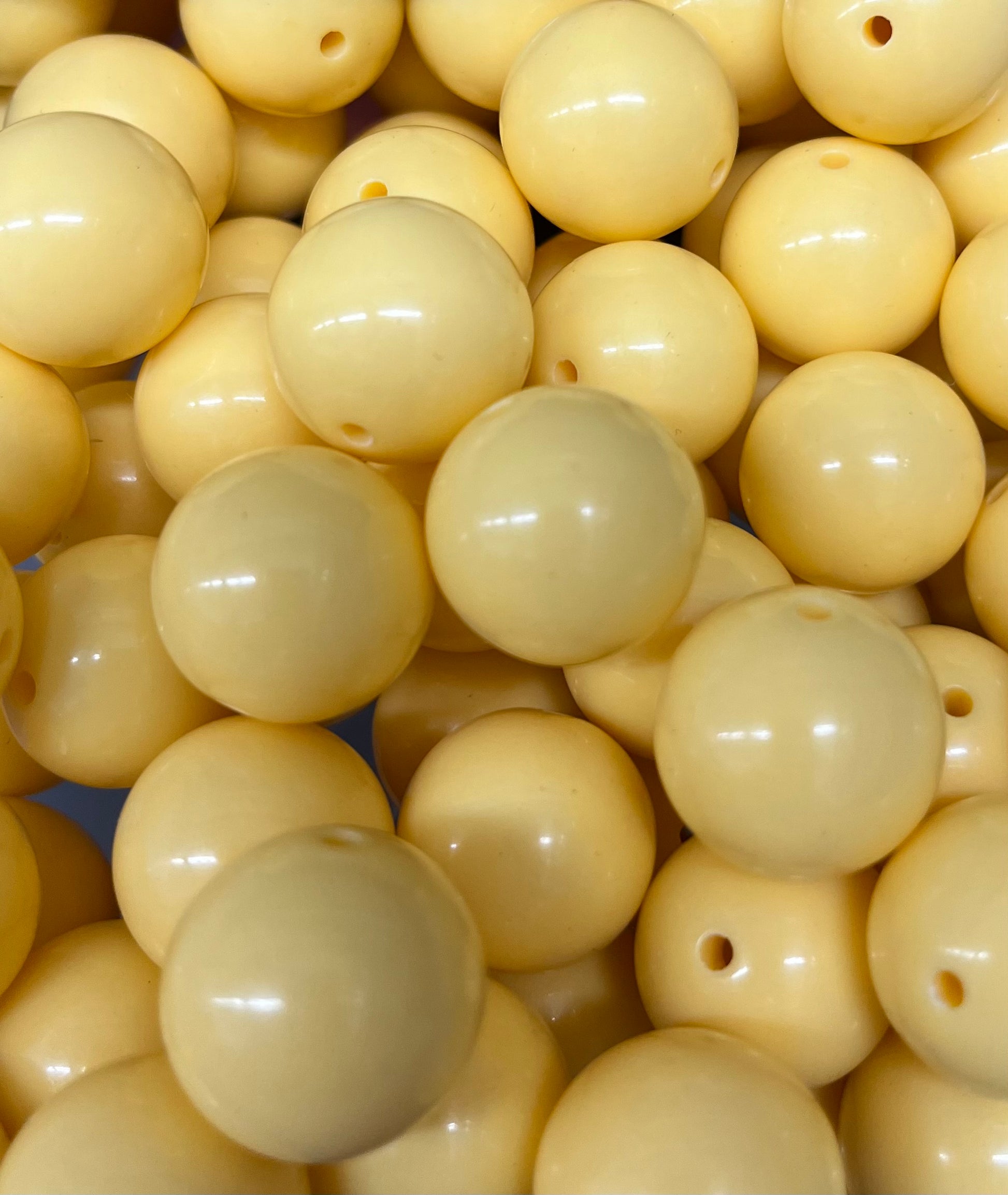 Close-up of 20mm light yellow bubblegum beads with glossy finish, perfect for jewelry and craft projects.