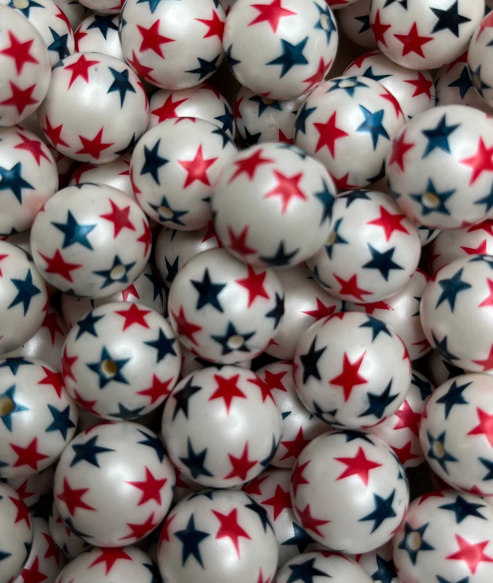 Close-up of 20mm white bubblegum beads with red and navy stars for patriotic crafts