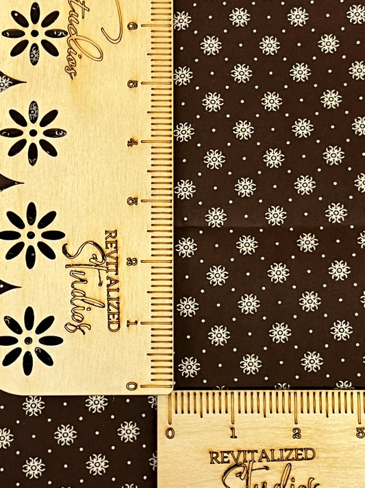 hocolate brown reproduction cotton fabric with cream snowflake star print, sold in fat quarters by Marshall Dry Goods.