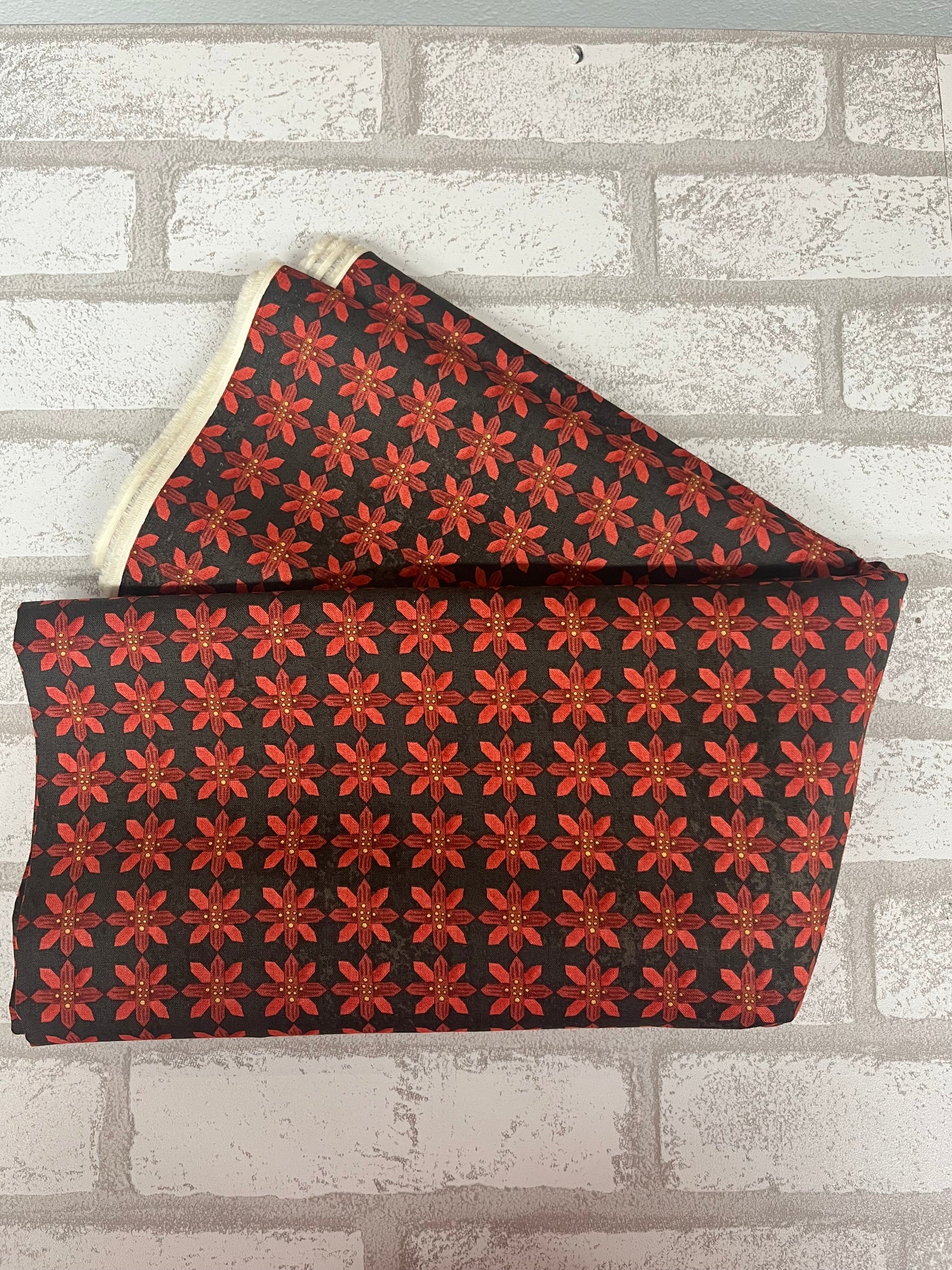 Festive poinsettia fabric fat quarter on black background, Kringle Collection by Riley Blake