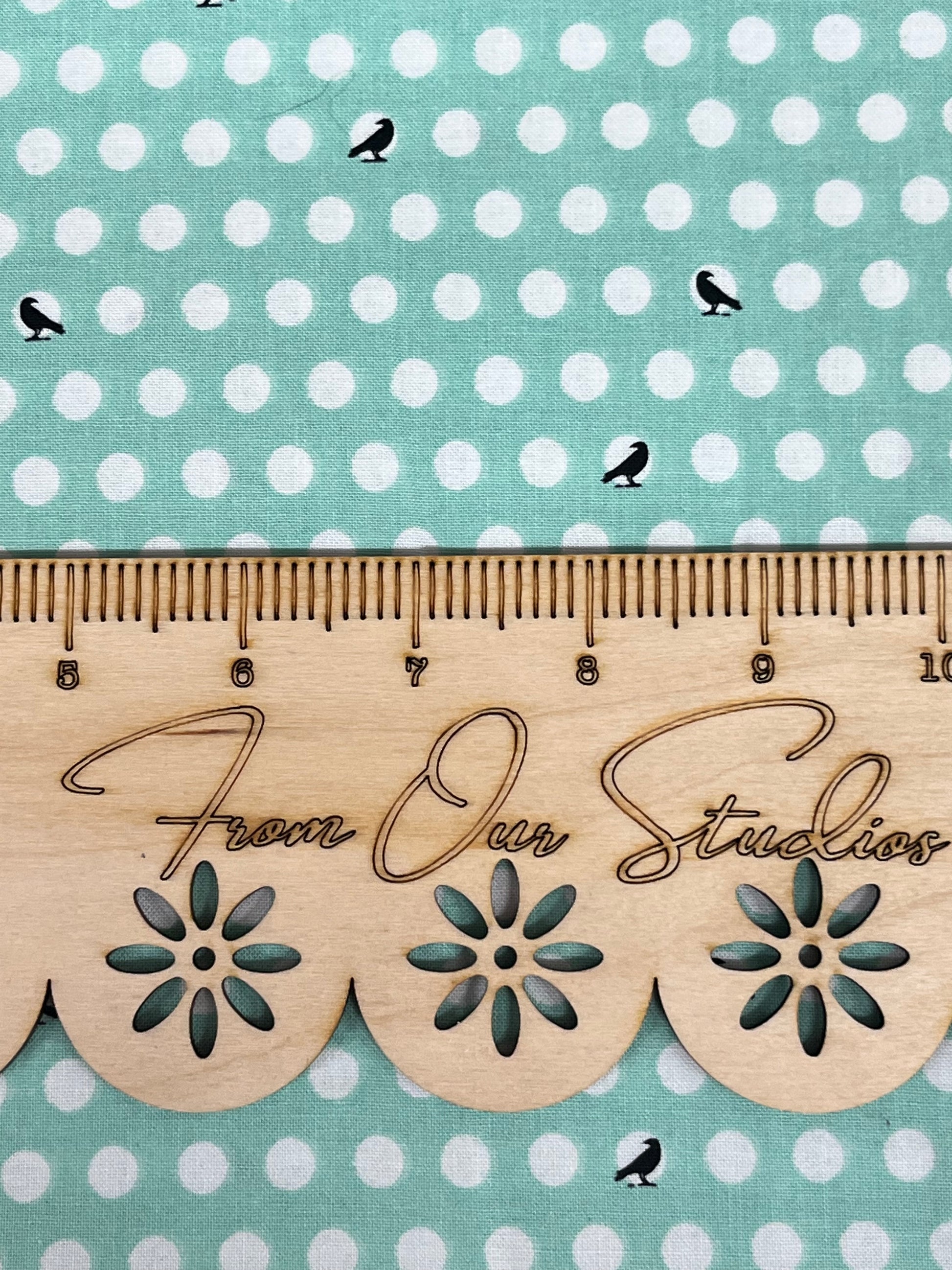 Close-up view of Riley Blake fat quarter showing playful black crow print on mint green cotton fabric.