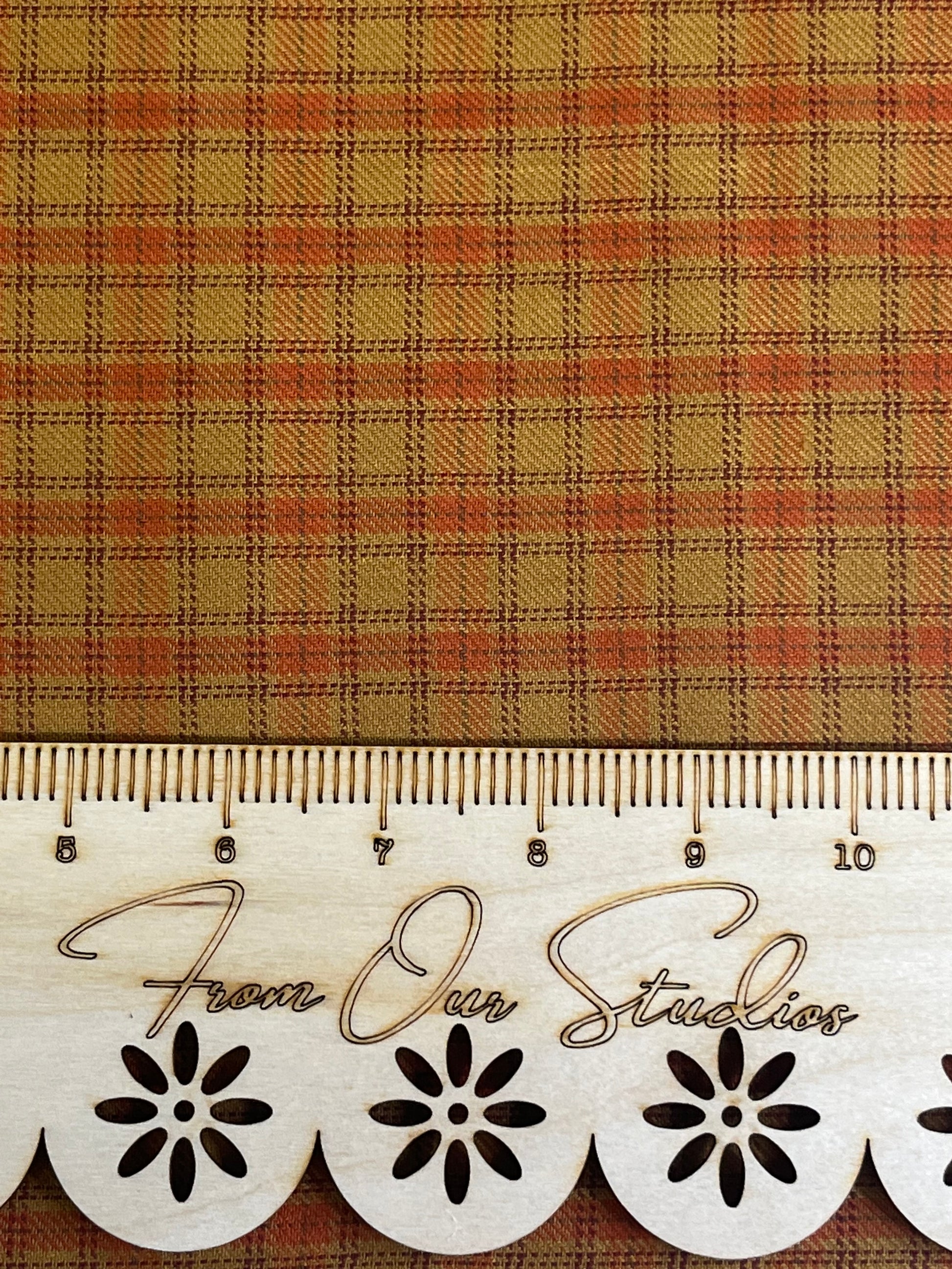 Detailed view of rustic plaid fabric in warm rust orange and mustard tones, medium-scale cotton print for sewing, quilting, and junk journal crafts