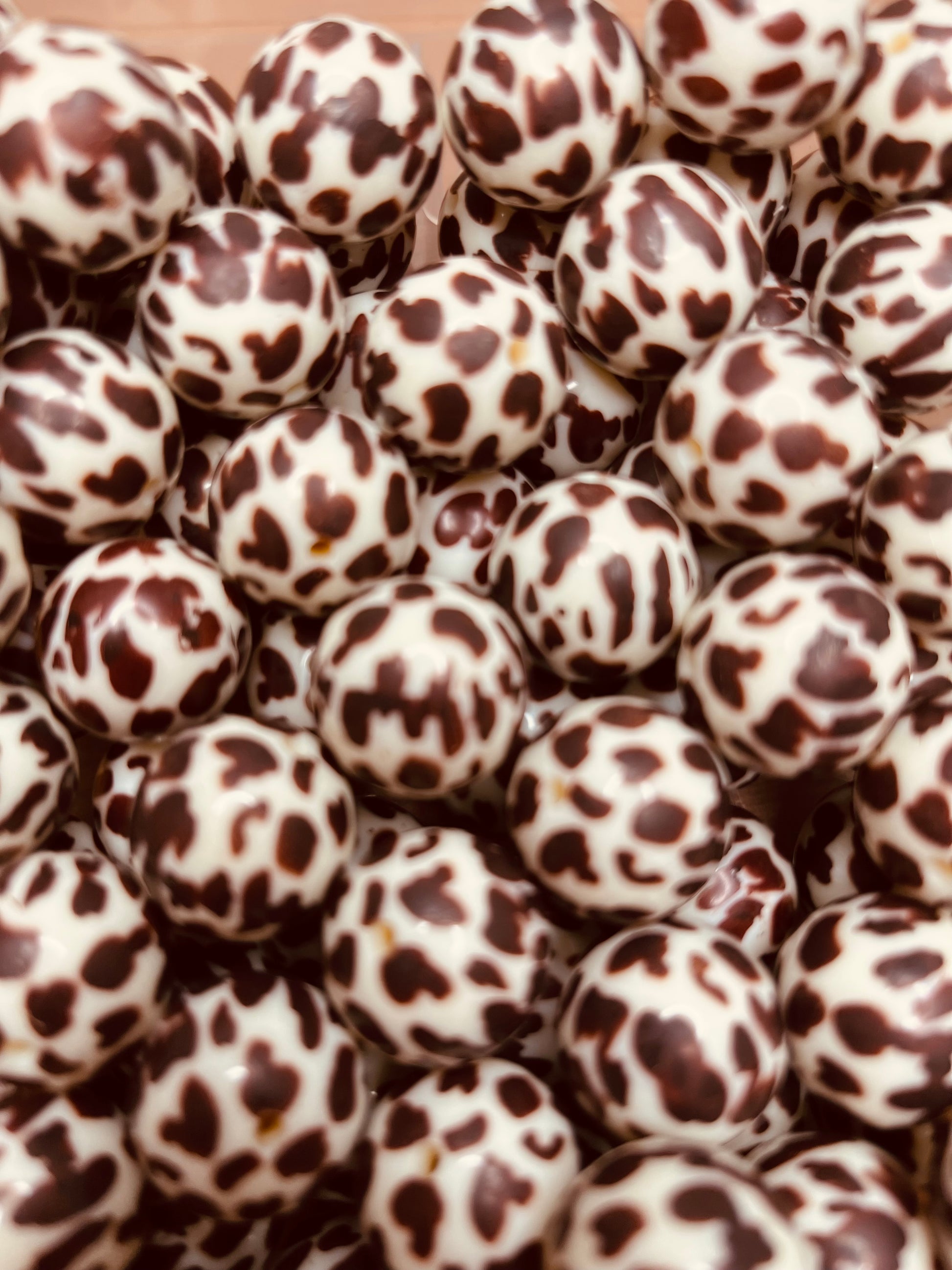 Close-up of brown and white cow print 20mm bubblegum beads – acrylic craft beads