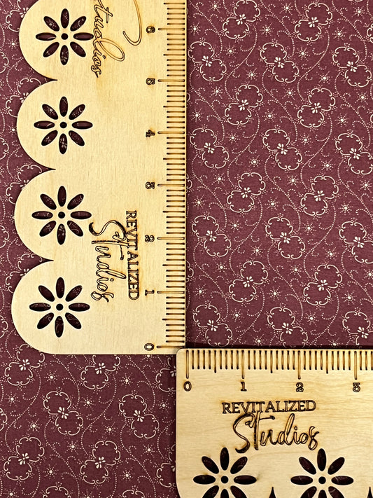 Close-up of deep mauve reproduction fabric with cream floral swirls, quilting cotton by Marshall Dry Goods.
