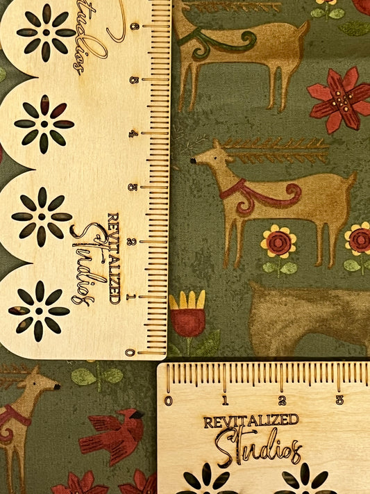 A green fabric fat quarter with a rustic reindeer design and a measurement scale on the side.