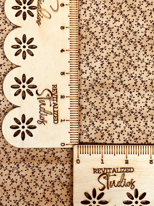 A fabric fat quarter with a red floral print on a marbled tan/brown background, labeled with 'Revitalized Studios'.