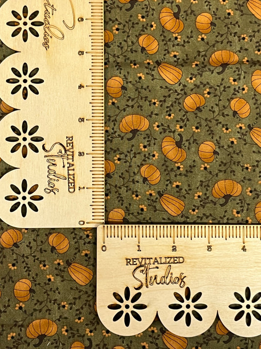Close-up of Moda Nature’s Kaleidoscope fabric by Sandy Gervais showing orange pumpkins on green background, cut in fat quarter size