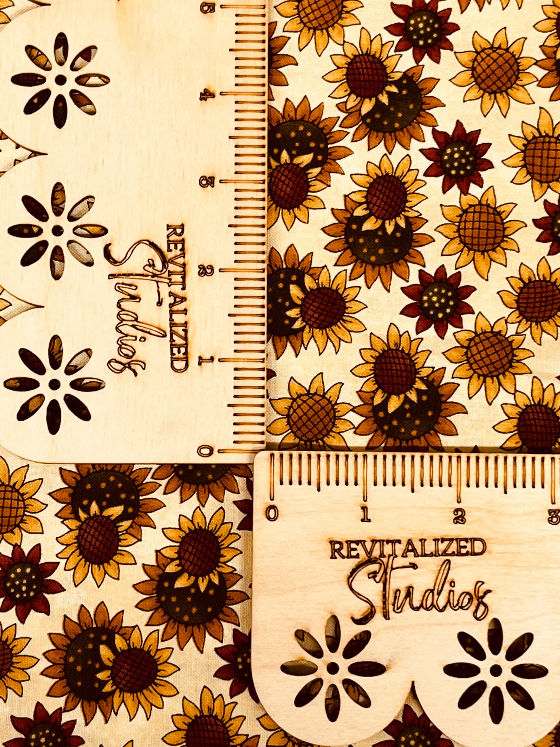 A fabric fat quarter featuring a kaleidoscope pattern with sunflowers design on a beige background, marked with the brand Moda and the text 'Revitalized Studios'.