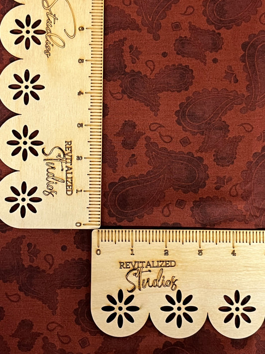 A fat quarter of paisley design fabric in rusty red with darker paisley, featuring the brand and design name 'Ride The Range' by Tara Reed.