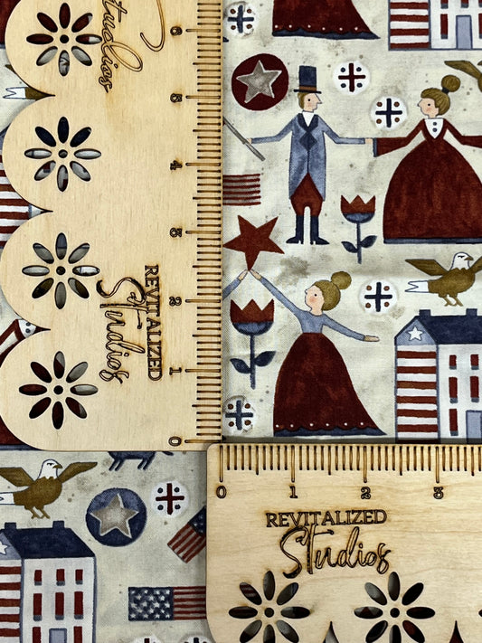 A fabric featuring a beige background with a pattern of stars, saltbox houses, and a depiction of an American flag in the style of Teresa Kogut's work.