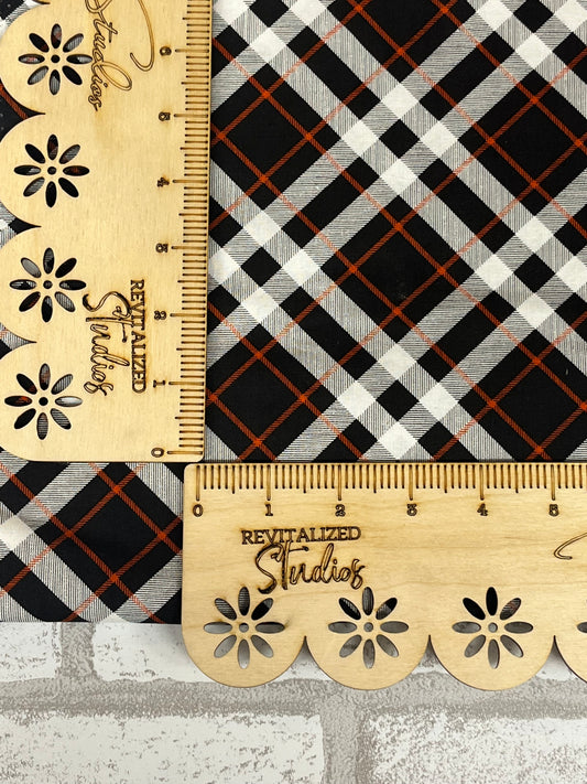 riley blake fabric fat quarter my minds eye plaid fabric in black, white, and orange plaid sitting on a ruler for scale