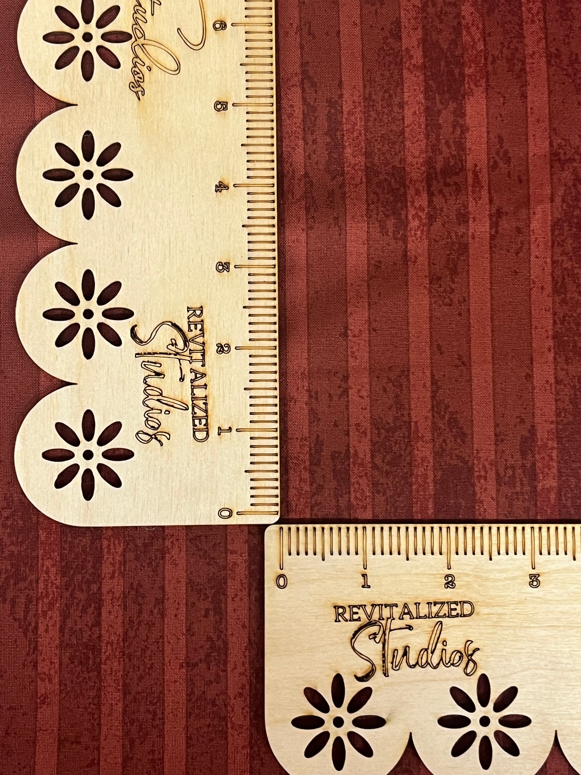 A close-up of a red striped fabric from the Kringle Collection by Teresa Kogut, showing the texture and brand embossment.