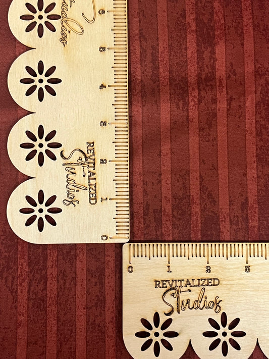A close-up of a red striped fabric from the Kringle Collection by Teresa Kogut, showing the texture and brand embossment.