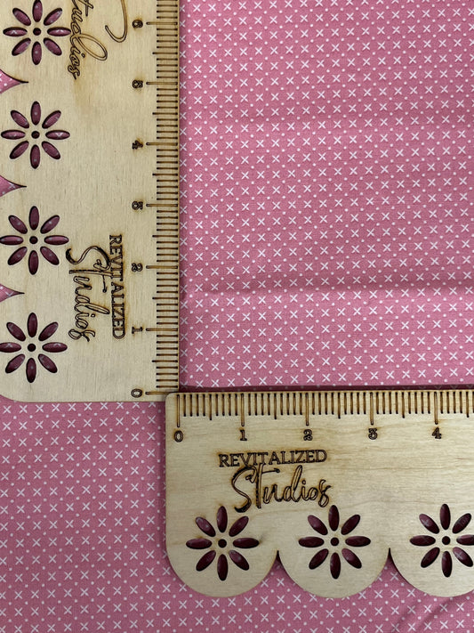 A fat quarter of fabric from the Tulip Cottage Collection with a pink background and floral designs, measuring 18 inches by 21 inches, displayed on a pink background