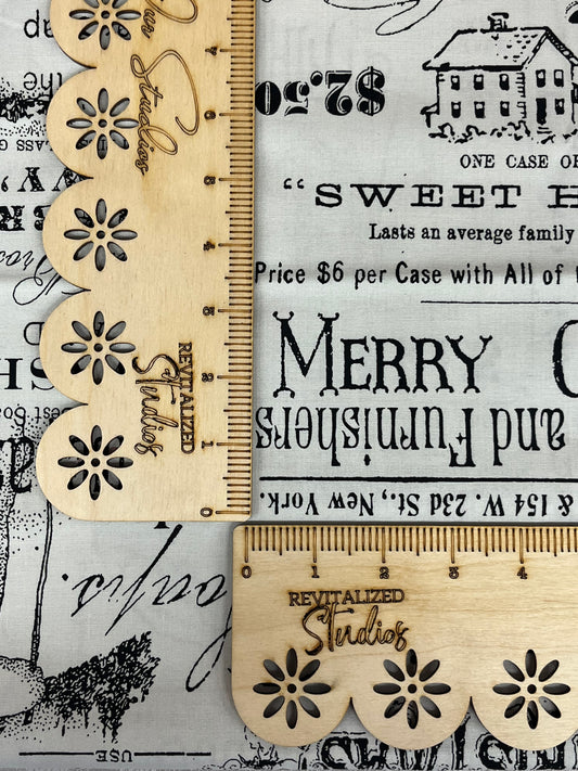 A fabric from the White As Snow Collection by J. Wecker Frisch for Riley Blake Designs, featuring a gray background with retro adverts and a ruler with decorative end caps.
