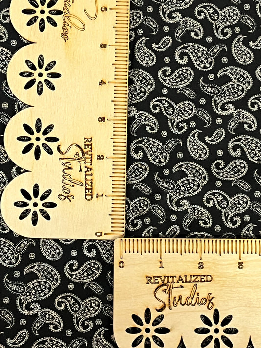 Marshall Dry Goods 1800s reproduction cotton fabric in black with cream paisley, shown with ruler for scale.